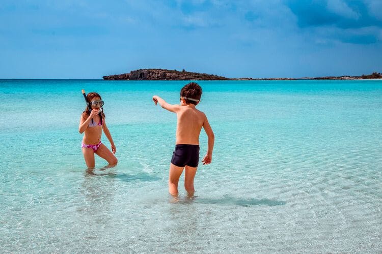 Two children in Cyprus play in the sea, about to go snorkeling