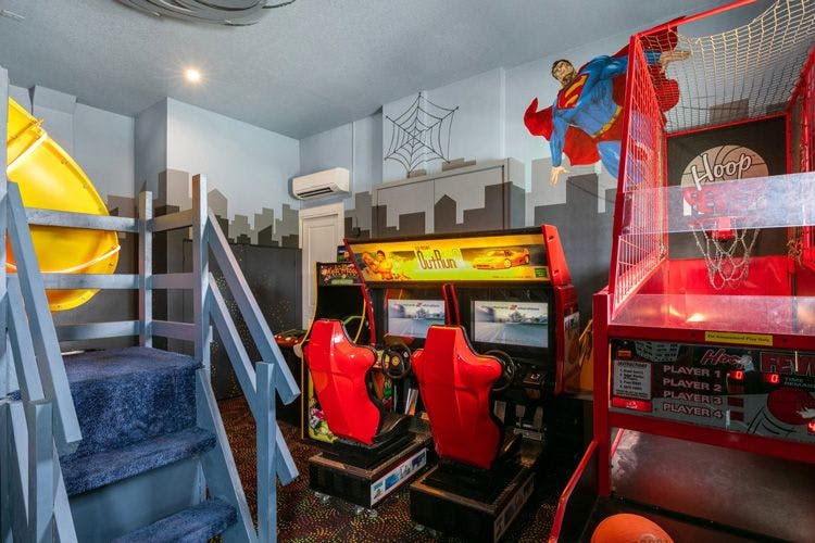 Reunion Resort 9000 vacation rental games room with arcade machines and indoor basketball game and superman painted on the wall