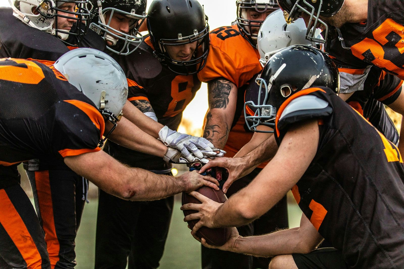 An American football team gather up and touch the ball before a match
