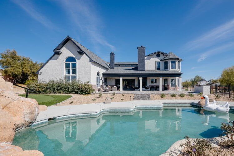 white and grey villa with pool in foreground