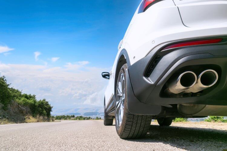 A close up of a car on a road with a blue sky in front