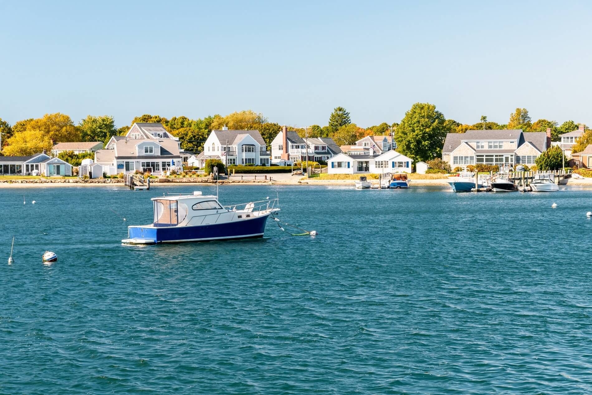 a boat with houses on the shore in the background