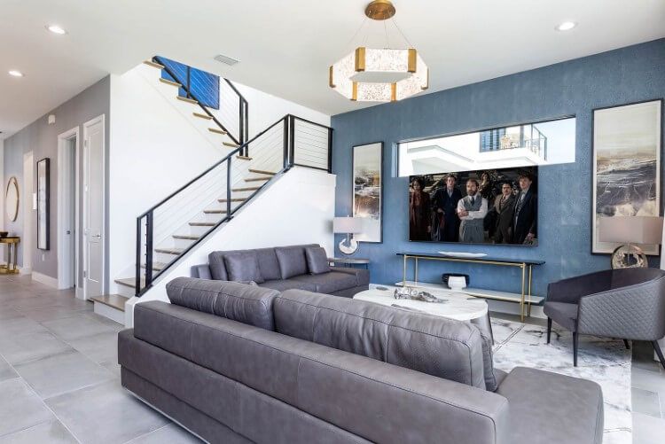 A bright and airy living room with large couches and a stairway at Villatel Harbor Island 3 vacation rental