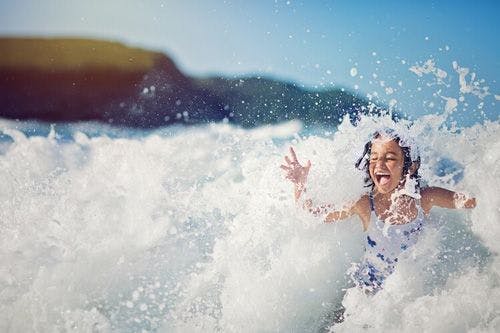 A young girl playing in the surf