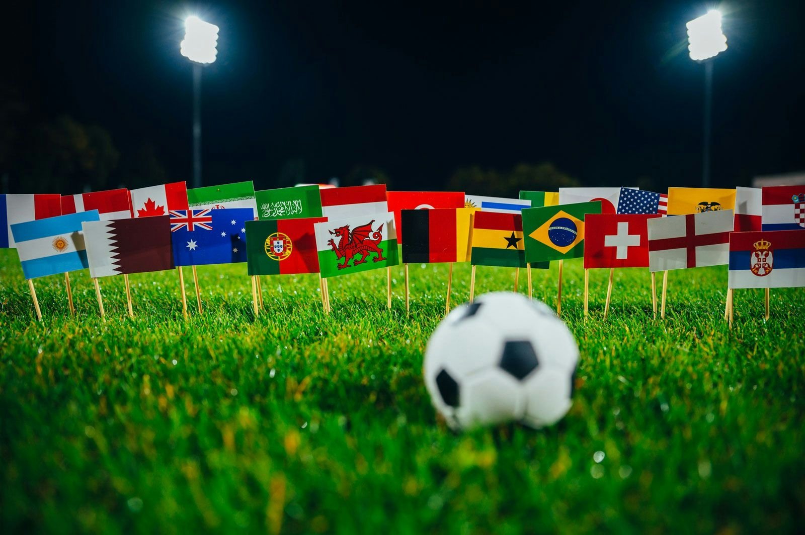 World Cup image of a football in front of world flags on a pitch