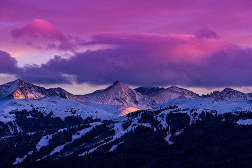 A purple sky over snow-capped mountains in Colorado