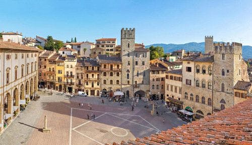 Arezzo central square with historic stone buildings around the central plaza