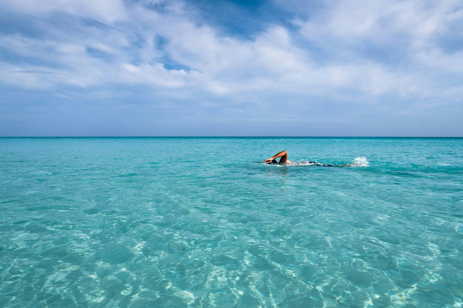 A person swimming through sparkling Caribbean Sea