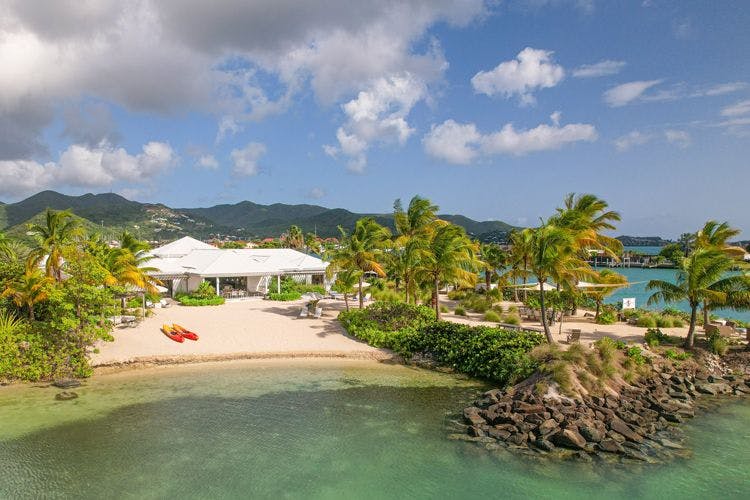 Beachfront villas in Antigua - Palm point villa on a white sand beach with two kayaks on the sand