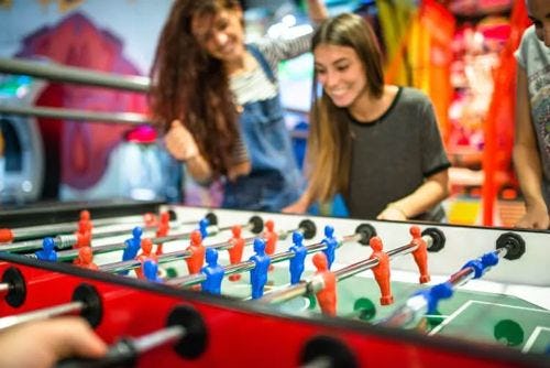 Two women playing a game of foosball