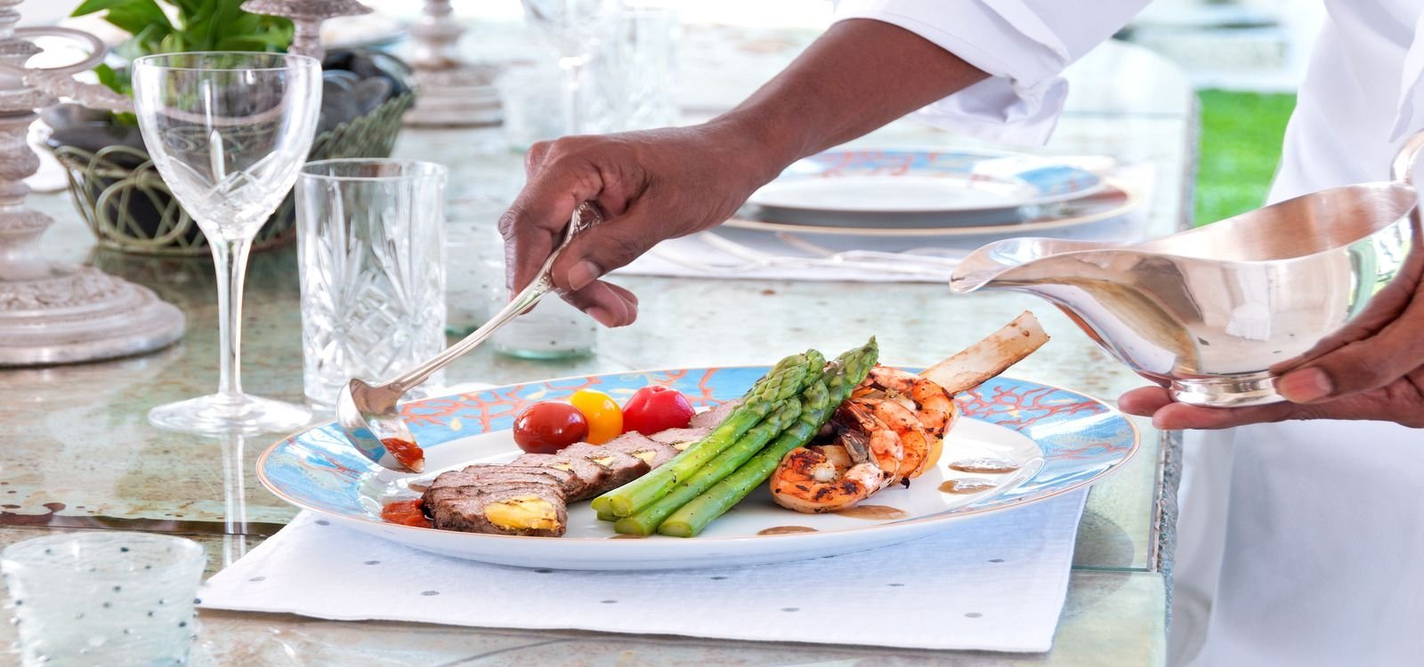 Caribbean chef serves a tasty homemade meal in a Top Villas Caribbean villa