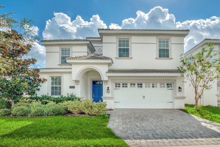 Championsgate 19 resort vacation rental exterior of large white home with blue door
