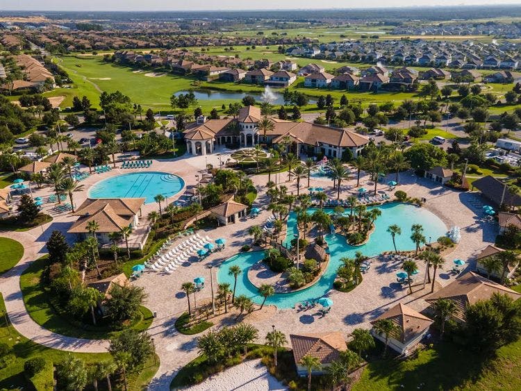 Champions Gate Resort aerial view of vacation rentals, community swimming pools, golf course, and club house