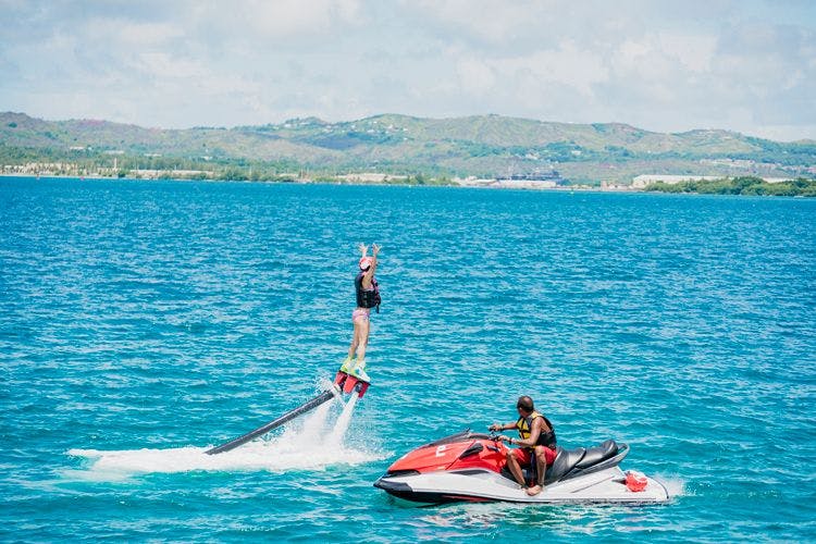 A woman on a flyboard and a man on a jet ski in the Caribbean Sea