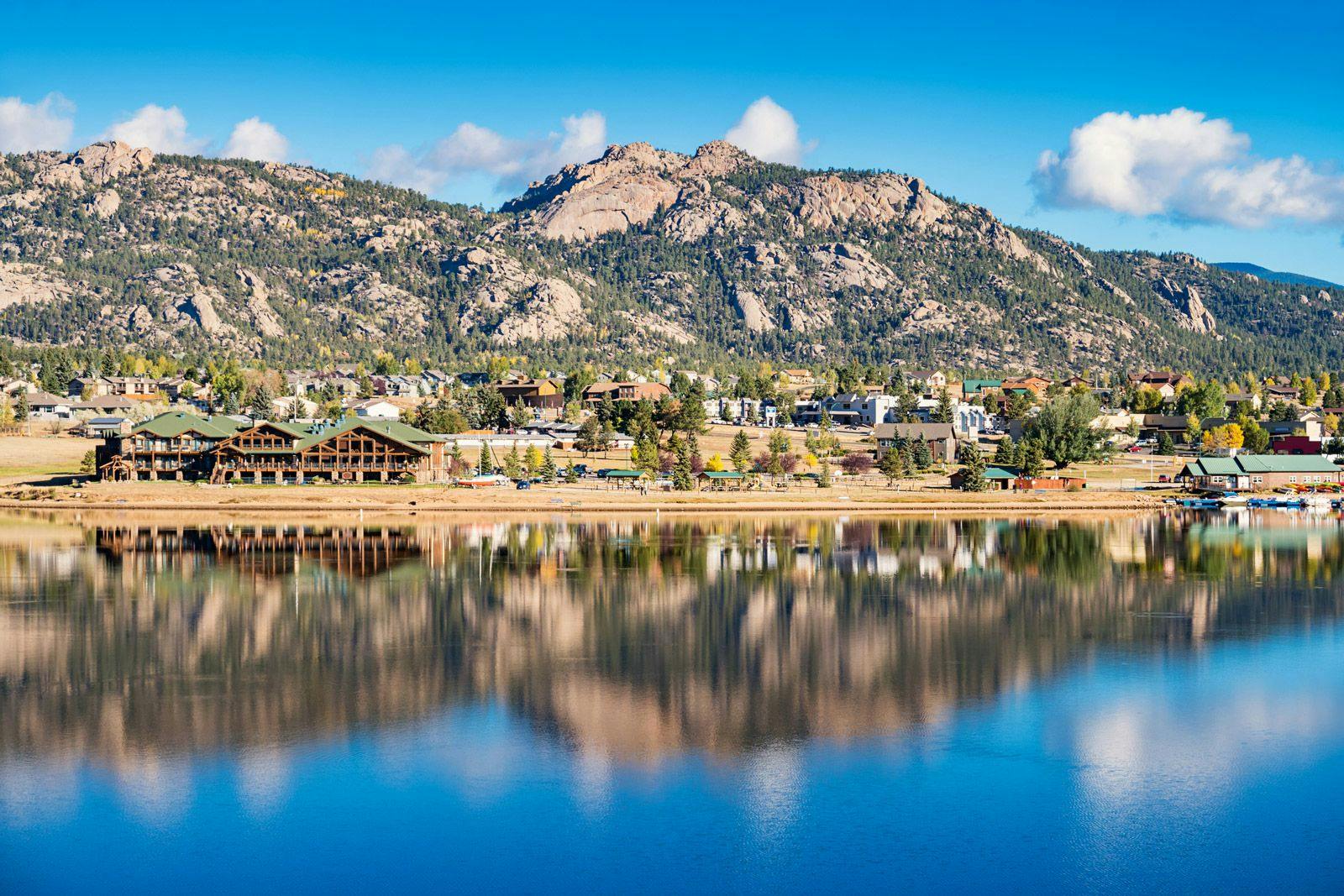 Estes Park town with mountains behind and a still lake in front