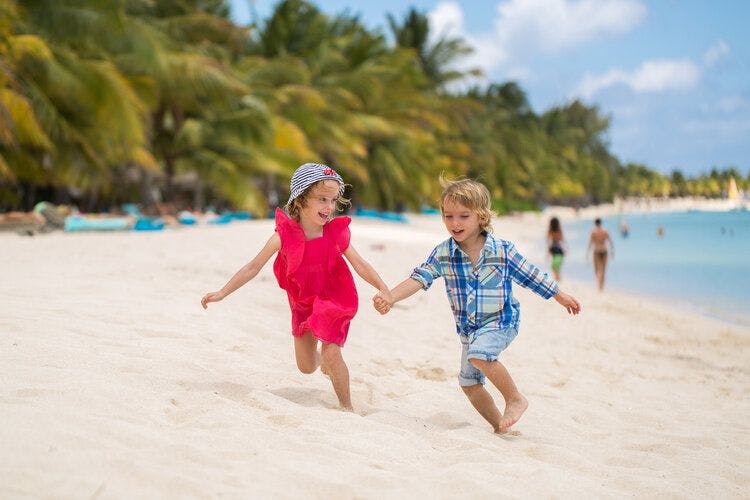 Happy kids play on the pristine sands of a Caribbean beach