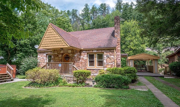 Fantastic pet friendly cabins in Gatlinburg - Gatlinburg 9 small vacation rental made of stone with porch and lawned garden 