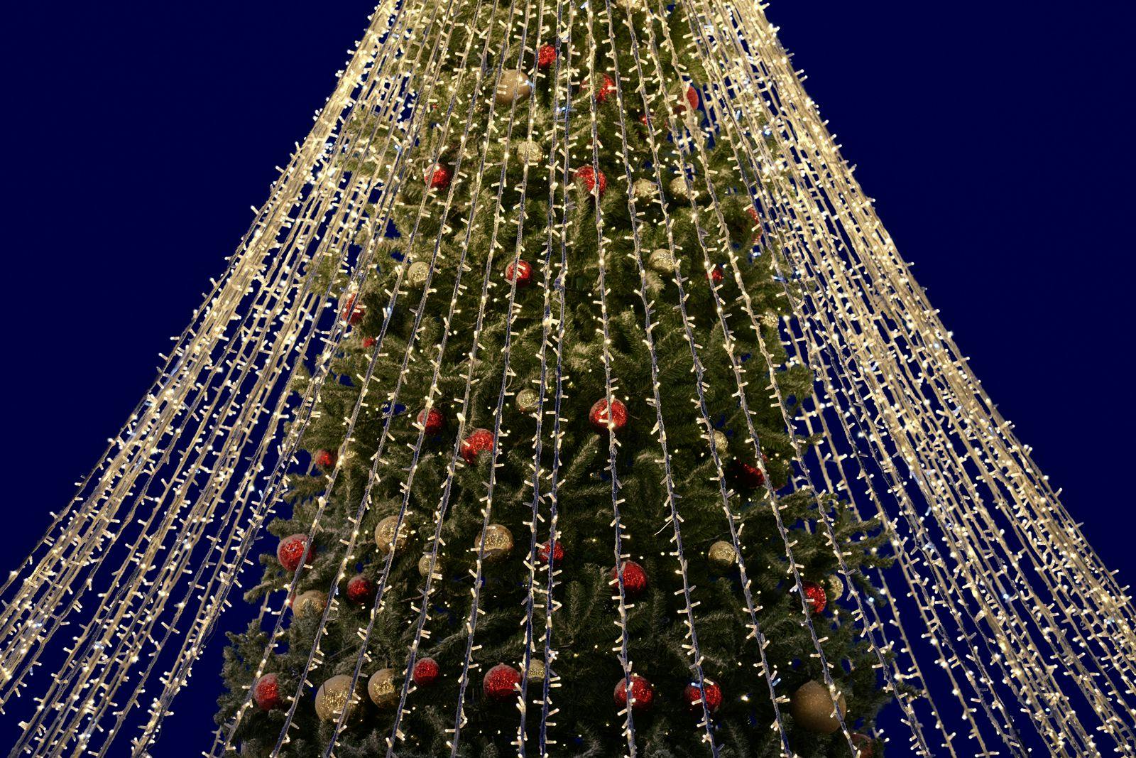 CLose up of a Christmas tree decorated with baubles and with garlands of lights
