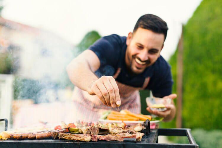 Private chef seasoning a BBQ feast