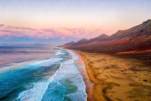 Fuerteventura coastline golden sand beach with volcanoes