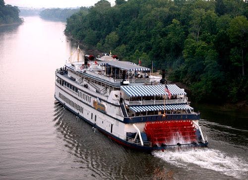 A paddle steamer going down a wide river in the USA