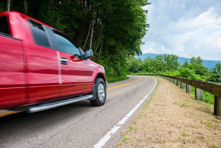A red pickup truck driving down a mountain road near Gatlinburg