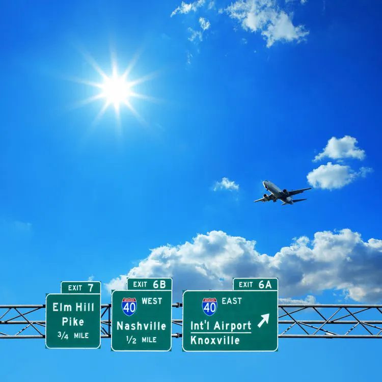 A plane flying low over a Tennessee roadsign