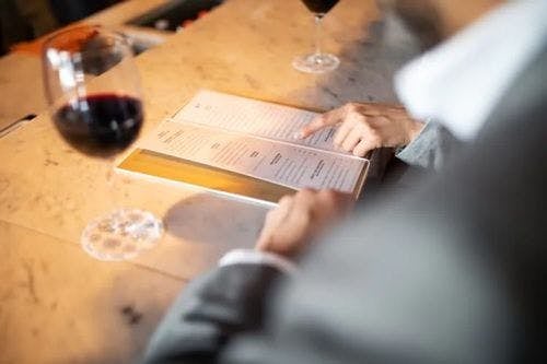 A person choosing food from a menu at a restaurant