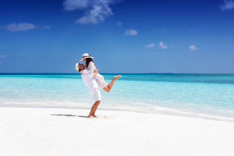 A couple on a white sandy beach enjoying our romantic Turks and Caicos honeymoon villas