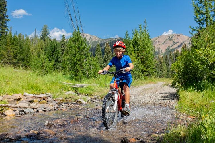 A boy mountain bikes along a Sun Valley trail