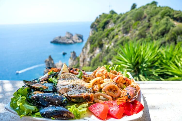 A delicious dish of Greek food overlooks the coast of Corfu