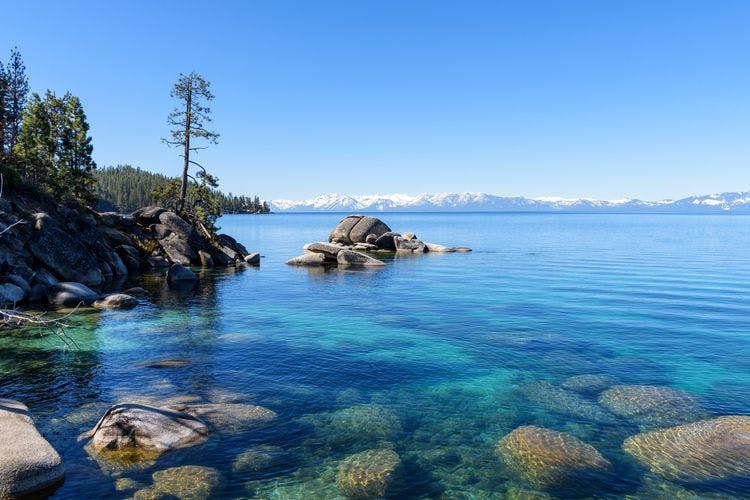 A tranquil view over Lake Tahoe in Nevada, with snowy peaks in the background