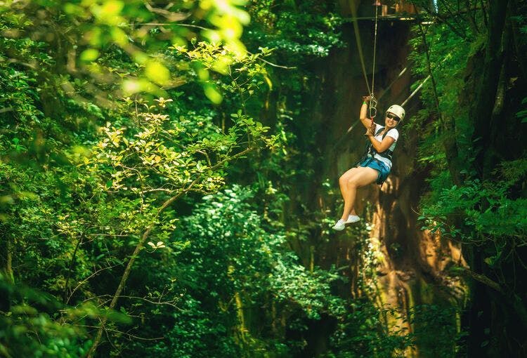  A lady goes ziplining over Hot Springs woodland