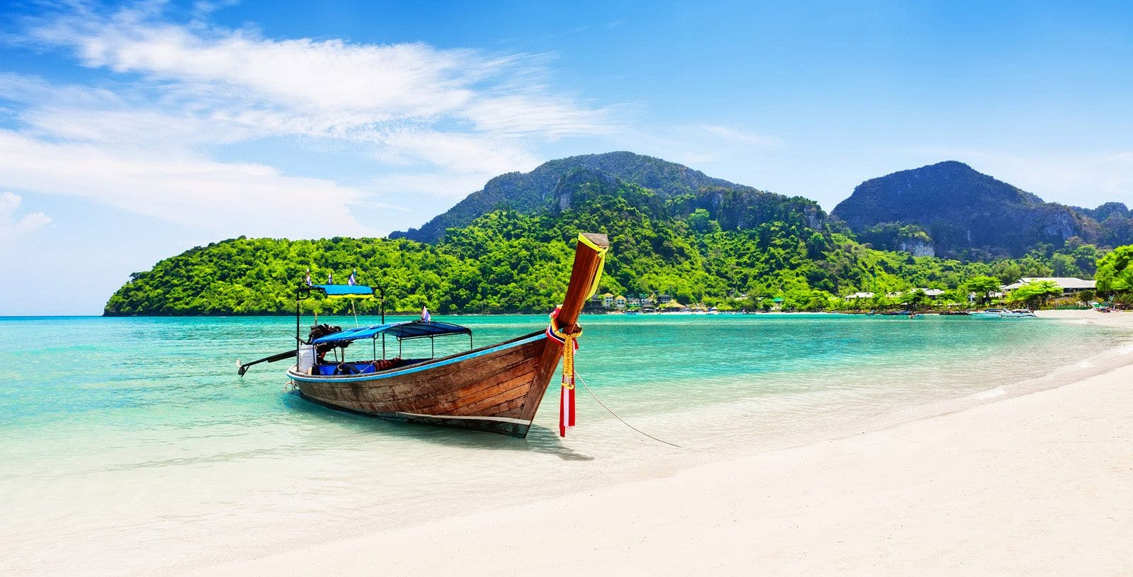 Traditional long-tail fishing boat on the beach in Thailand