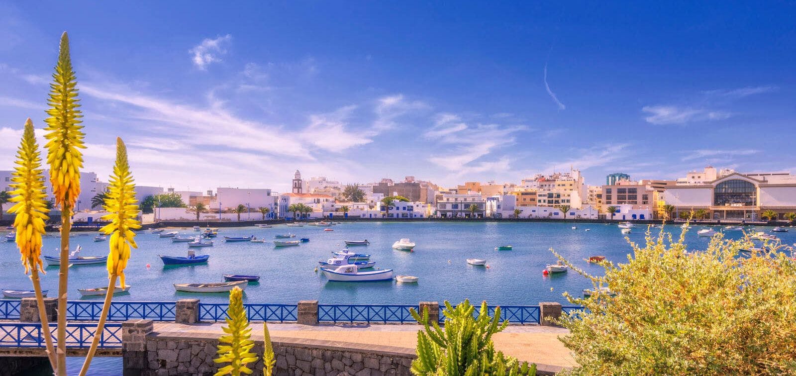 Lanzarote town with harbor and fishing boast in the water