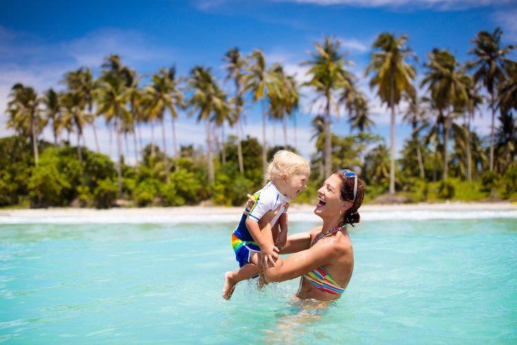 Last minute holidays, young family in the sea at the beach, Top Villas
