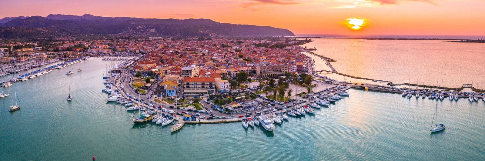 View of Lefkada town at sunset with sailboats in the harbor