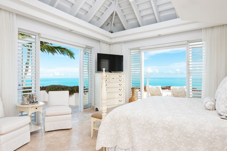 Long Bay Beach villas with sea views - Lidija House bedroom with white furnishings and sea views