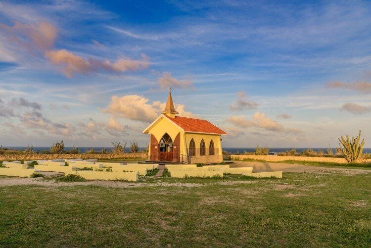 A small yellow and red church on the seafront in Noord, Aruba