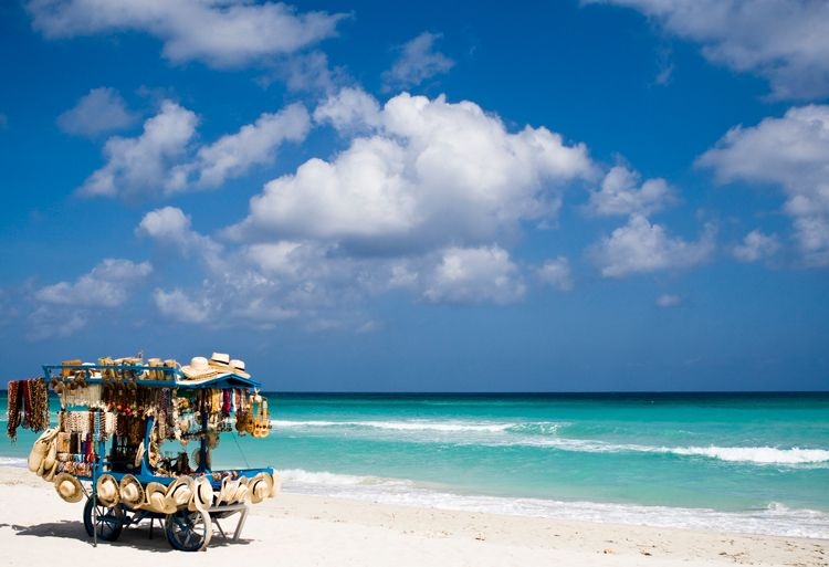 Souvenir stall with hats, sunglasses and jewelry on a white sand beach