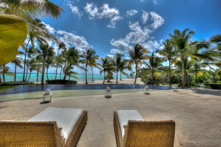 Punta Cana beachfront villa rentals - Cap Cana 13 outside seating wrea with view of palm trees, beach, and sea