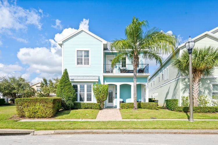 Reunion Resort 27 4 bedroom vacation rental in Orlando Florida blue-painted home with palm tree out front
