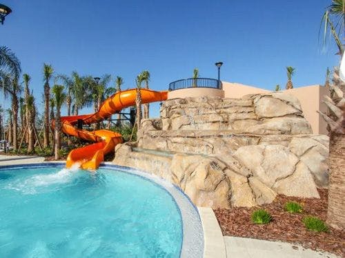An orange water slide into a pool at Solterra Resort