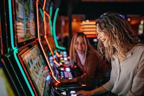 Two women playing on arcade machines