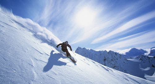 A person skiing down a powder slope