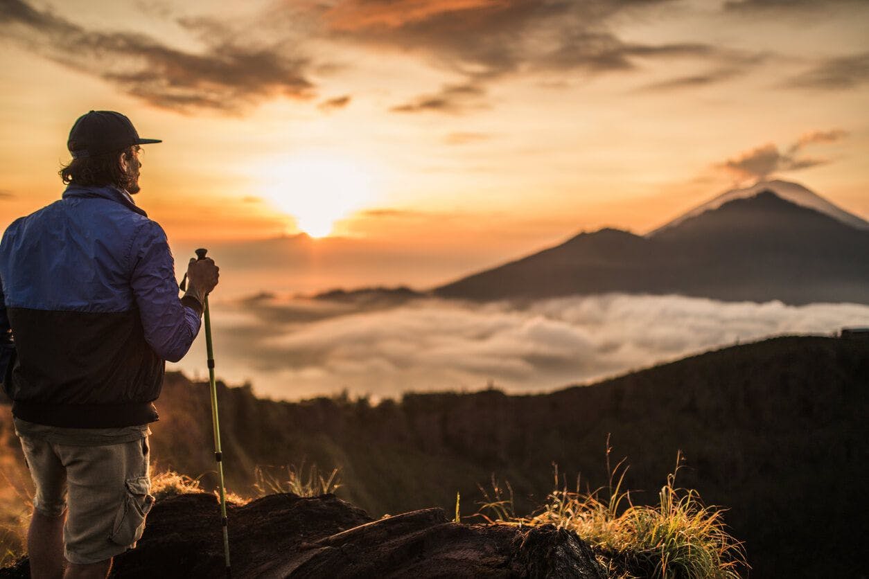 A man takes in the sunset from a Bali mountain top