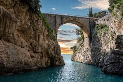 An arched stone bridge over a fjord in Italy