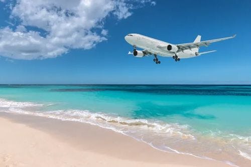 A plane coming in low to land at the airport by Maho Beach