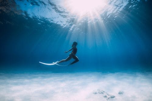 A woman freediving in shallow water