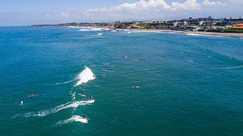 Ariel view of Canggu Beach, with people surfing the waves